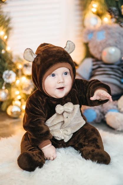 Un niño pequeño disfrazado de oso de peluche marrón se sienta en el