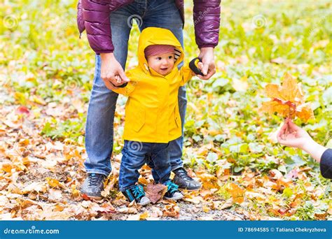 Father And Son Walking Baby Taking First Steps With Father Help In