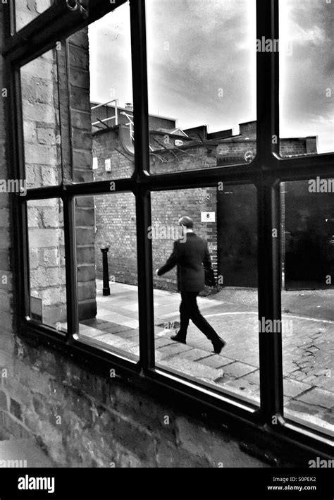 Man walking in a narrow street seen and framed through a window. At Chad's Place, kings Cross ...