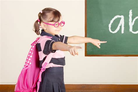 Petite Fille Heureuse Décole à La Pièce De Classe Décole Photo Stock