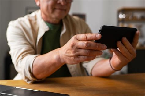 Portrait d un homme plus âgé utilisant un smartphone à la maison