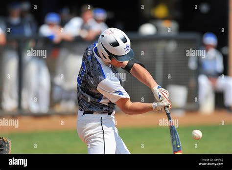 During A High School Baseball Game A Batter Swings While Making Solid