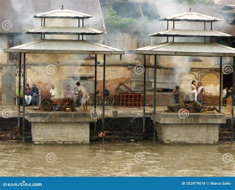 People Next To Two Corpses Being Cremated On Two Funeral Pyres At The