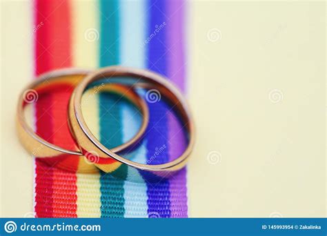 Pares De Alian As De Casamento Douradas Na Fita Do Arco Ris De LGBT No