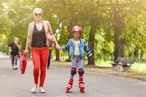 joven madre con su hija de 5 años patinando en el parque 16781061 Foto