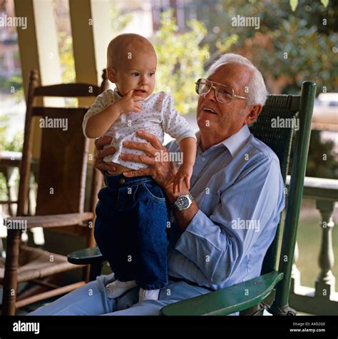 Grandfather In Rocking Chair Holding A Young Girl Stock Photo Alamy