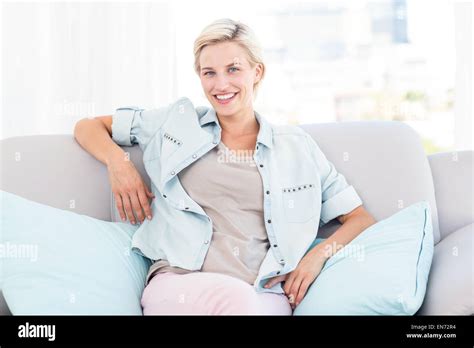 Pretty Blonde Woman Sitting On The Couch And Smiling At The Camera Stock Photo Alamy