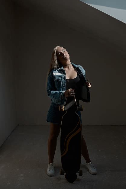 Belle Fille Blonde Posant Avec Un Loangboard Photo Gratuite