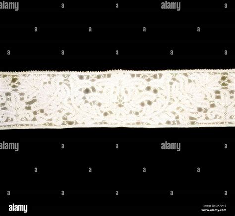 A delicate lace ribbon featuring intricate floral patterns and ...
