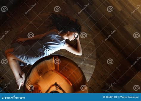 A Brunette With Long Hair Sits On A Table In A Cafe Dressed In A Light Blue Dress Top View
