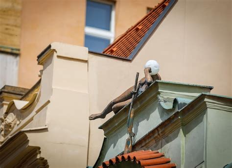 Premium Photo A Sculpture Of A Naked Girl Lying On The Edge Of The Roof Of A Building With A Gun