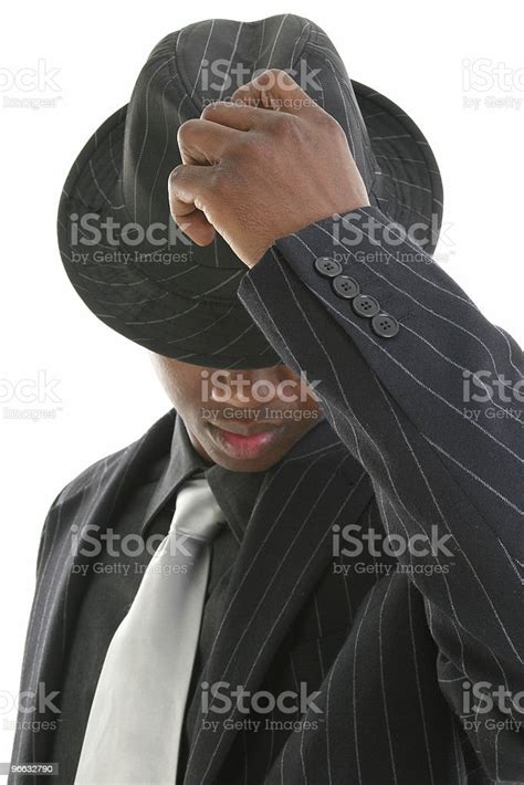 Attractive Young Man In Pinstripe Suit Tipping His Hat Stock Photo