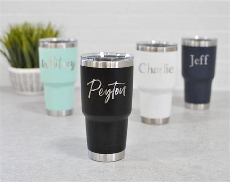 four personalized yeti cups sitting next to each other on top of a table