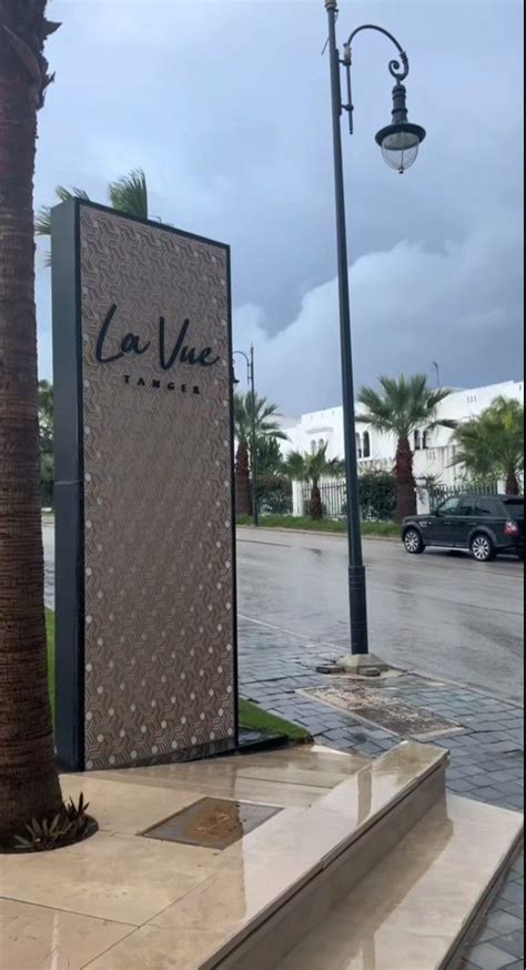 A Palm Tree Sitting On The Side Of A Road Next To A Tall Sign That Says