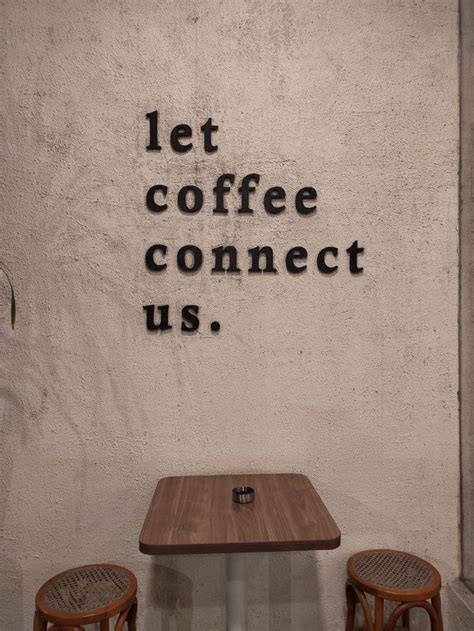 Two Chairs And A Table In Front Of A Wall That Says Let Coffee Connect Us