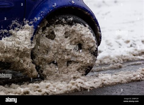 A car driving through snow, slush and ice on a road in winter Stock ...