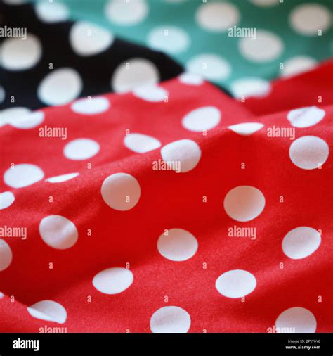 White polka dots on red pink background, textile fabric surface ...