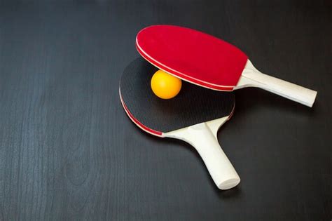 Dos Raquetas De Tenis De Mesa O Ping Pong Y Pelota Sobre Un Fondo Negro