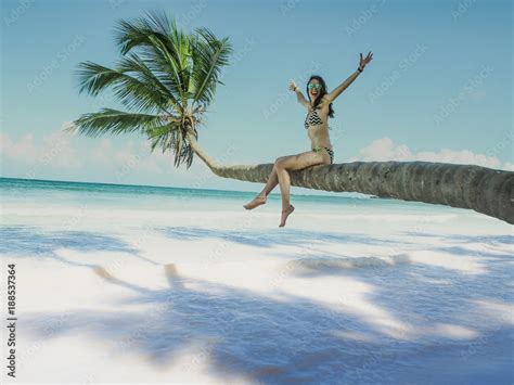 Bikini Woman Sitting On Palm Tree At The Ocean Stock Photo Adobe Stock