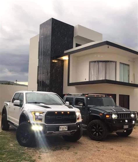 Two Pickup Trucks Parked In Front Of A House