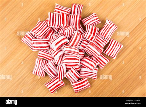 Red and white striped holiday candy isolated over white Stock Photo - Alamy