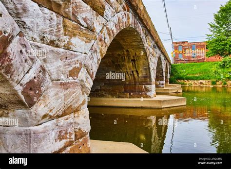 River flowing under white on stone bricks of earth tone golden hues and ...