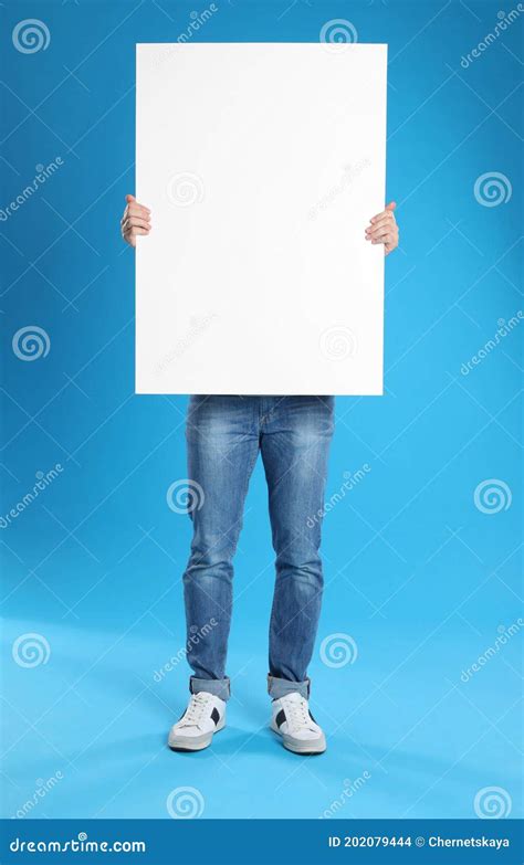 Homem Segurando Cartaz Em Branco Sobre Fundo Azul Foto De Stock