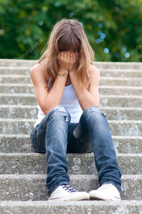 Sad teenage girl sitting alone on the stairs — Stock Photo ...