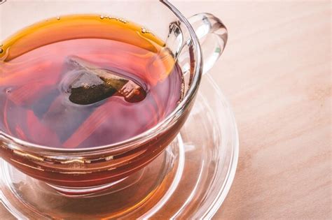 Premium Photo A Cup Of Tea On The Wooden Table Tea Bag In Glass