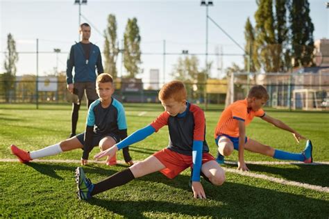 Jóvenes Futbolistas Haciendo Ejercicio De Calentamiento Estirando Las