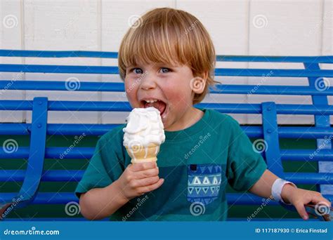 Young Boy Smiling While Licking An Ice Cream Cone Stock Photo Image