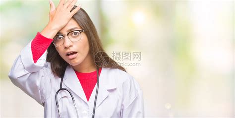 年轻的阿拉伯医生女人在与世隔绝的背景下惊讶地用手捂着头高清图片下载 正版图片505452030 摄图网