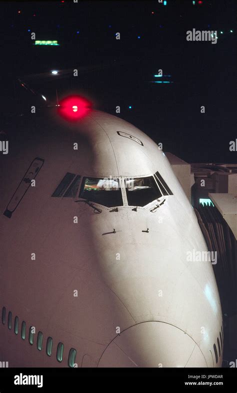 nose and windshield of a Boeing 747-200 at night with red light on top ...