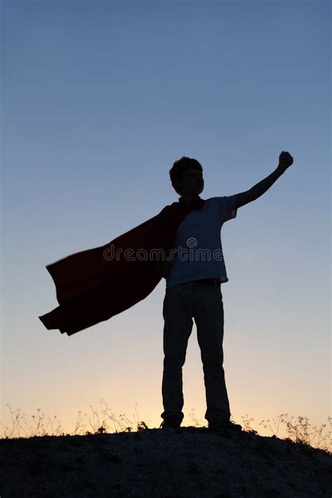 Boy Playing Superheroes On The Sky Background Silhouette Of Tee Stock