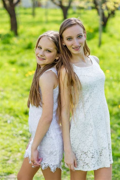 Deux Belles Jeunes Filles Dans Des Robes Blanches En T Photo Stock