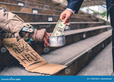 Businessman Giving Donation Dollar Cash With Sleeping Homeless P Stock