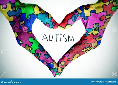 Text Autism And Hands Forming A Heart With Puzzle Pieces Stock Photo