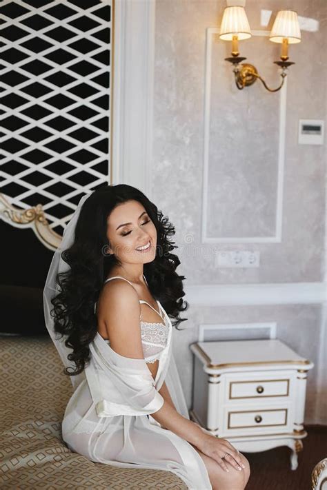 Beautiful And Brunette Model Girl In Fashionable Lingerie Posing On The Bed At Classic Interior