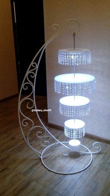 A Three Tiered Cake Stand With Lights On It In The Middle Of A Room