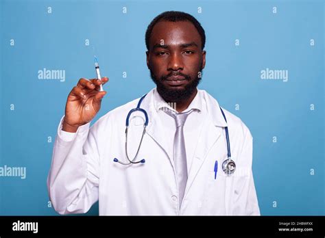 Confident Doctor In White Lab Coat Holding Syringe With Hypodermic