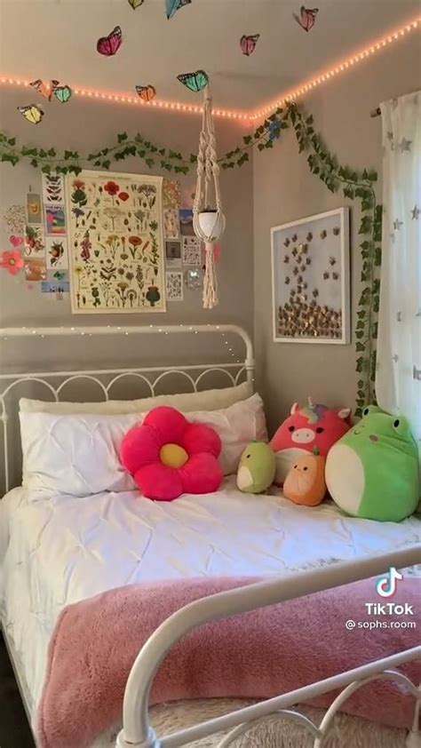 A White Bed Topped With Lots Of Pillows Next To A Wall Covered In