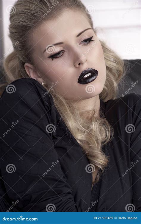 Fille Blonde Sur Le Sofa Avec Les Languettes Noires Image Stock Image