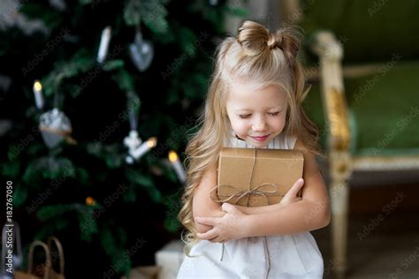 Happy cute little smiling girl with christmas gift box. Merry Christmas ...