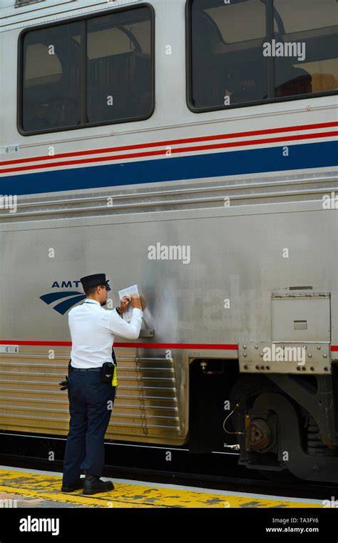 An Amtrak conductor completes paper work after picking up passengers at ...