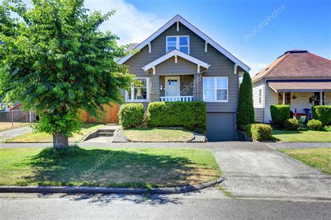 Classic American house exterior with siding trim and well kept garden ...