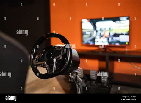 A racing simulator wheel and pedals setup in a home environment, with a ...