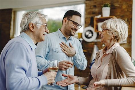 Heureux Couple Mature S Amusant Tout En Communiquant Avec Leur Fils Adulte Dans La Cuisine