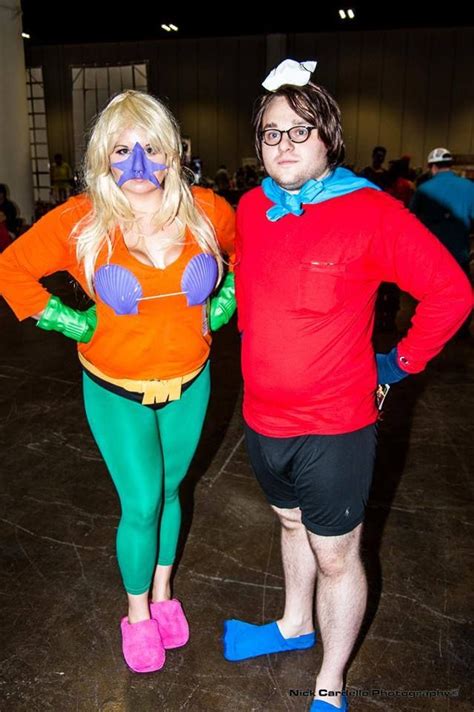 Two People In Costumes Standing Next To Each Other