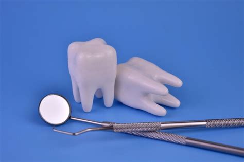 Ferramentas Dentárias E Dentes Em Fundo Azul Conceito De Odontologia Foto Premium