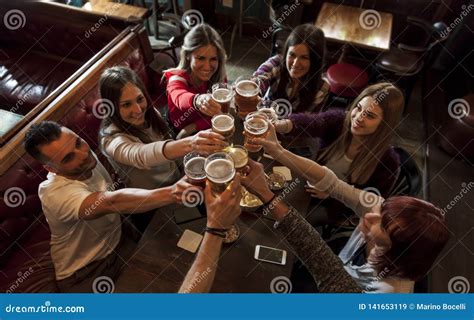 Group Of People Celebrating In A Pub Drinking Beer Stock Image Image